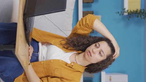 Vertical-video-of-Young-woman-working-on-laptop-has-a-headache.
